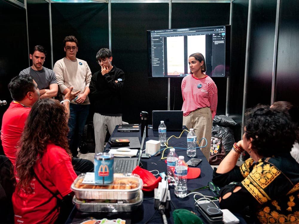 Sesión de mentoría con un equipo frente a una pantalla